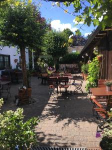 un patio con tavoli, sedie e un albero di Hotel & Weinhaus Zum Schwarzen Bären a Coblenza