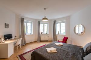 Schlafzimmer mit einem Bett, einem Schreibtisch und Fenstern in der Unterkunft Apartment CHOPIN in Marienbad