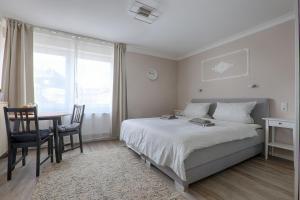 a bedroom with a bed and a desk and a table at H-Apartments Bismarckstrasse in Trier