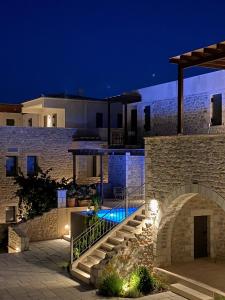 a villa with a swimming pool at night at Margo Beach Hotel in Gythio