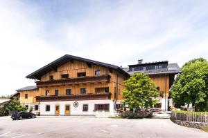 un grande edificio in legno con un'auto parcheggiata di fronte di Gasthof Steinerwirt a Grossgmain