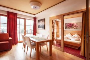 une chambre avec une table à manger et une chambre dans l'établissement Naturresort Senningerhof, à Bramberg am Wildkogel