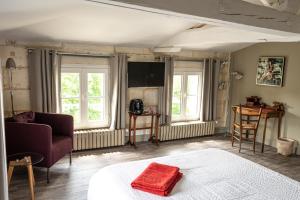 Habitación con cama, sofá y ventanas. en La Tillaie SPA et Sauna, en Pont-lʼAbbé-dʼArnoult