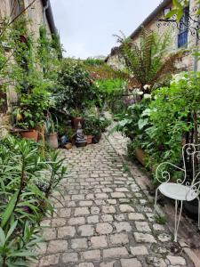 a stone pathway with a bench in a garden at Terra-Crystal in Rochefort