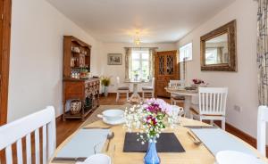 une salle à manger avec une table et des fleurs dans un vase bleu dans l'établissement Avalon House B&B, à Lyndhurst