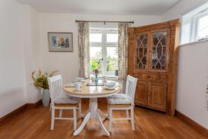 d'une salle à manger avec une table, des chaises et une fenêtre. dans l'établissement Avalon House B&B, à Lyndhurst