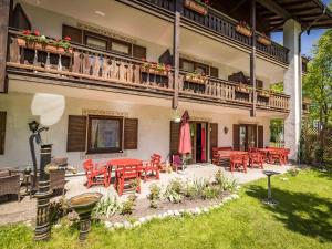 een patio met rode stoelen en tafels in een gebouw bij Hotel Am Rupertuspark in Bad Reichenhall