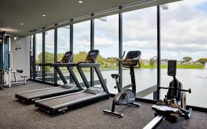 a gym with three cardio machines in front of the water at Punthill Caroline Springs in Caroline Springs