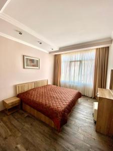 una camera con un letto con copriletto rosso di Villa Old Batumi a Batumi