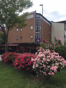 een bos roze bloemen voor een gebouw bij Hotel Millenium2 in Prizren