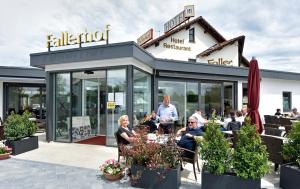 un gruppo di persone seduti a un tavolo fuori da un ristorante di Hotel Restaurant Fallerhof a Bad Krozingen