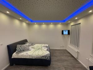 een slaapkamer met een bed met blauwe verlichting aan het plafond bij CityGlückNms - Direkt am Bahnhof und Einkaufszentrum in Neumünster