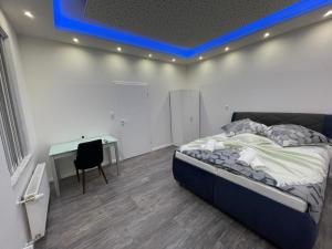 een slaapkamer met een bed en een bureau met een blauw licht bij CityGlückNms - Direkt am Bahnhof und Einkaufszentrum in Neumünster