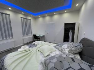 een slaapkamer met een bed met een blauw licht aan het plafond bij CityGlückNms - Direkt am Bahnhof und Einkaufszentrum in Neumünster