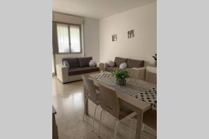 een woonkamer met een tafel en een bank bij Lario Promenade: family friendly apartment in Como in Como