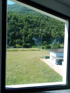 een raam met uitzicht op een veld en een gebouw bij I viaggi del Lea in Cadenazzo