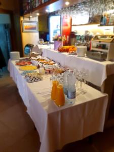 ein Buffet mit weißen Tischen mit Speisen und Orangensaft in der Unterkunft Boutique Hotel Melissa in Poreč