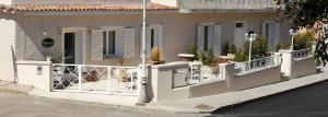 a white fence in front of a house at MarMè in San Teodoro