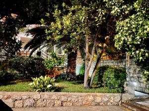 un albero di fronte a una casa con un muro di Ida 2 Apartments a Dubrovnik