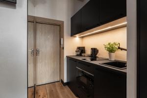 ソポトにあるMorning Light Sopot Apartmentのキッチン(黒いカウンター、シンク付)