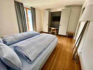 a bedroom with a large bed and a table at Hotel Müller - mountain lodge in Pontresina