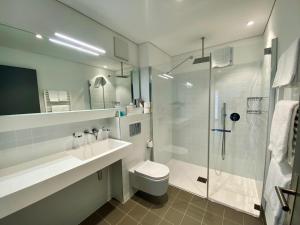 a bathroom with a shower and a toilet and a sink at Hotel Müller - mountain lodge in Pontresina