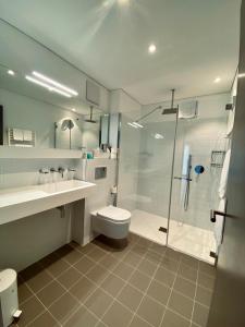 a bathroom with a shower and a toilet and a sink at Hotel Müller - mountain lodge in Pontresina