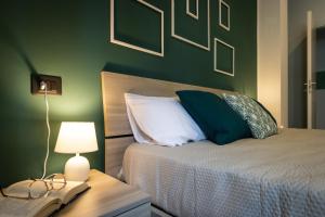 um quarto com uma cama e uma mesa com um candeeiro em Green Pearl ✰✰✰✰✰ Appartamento a 100 metri dal lago em Arona