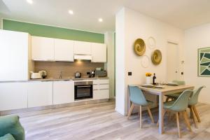 uma cozinha e sala de jantar com mesa e cadeiras em Green Pearl ✰✰✰✰✰ Appartamento a 100 metri dal lago em Arona