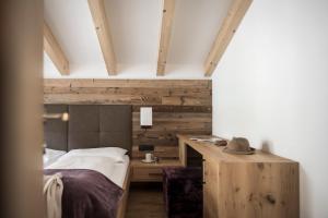 Schlafzimmer mit einem Bett und einem Holzschreibtisch in der Unterkunft Gamz Villa in Sexten