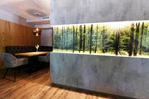 a restaurant with a painting of a forest at Hotel Beethoven in Hinterbrühl