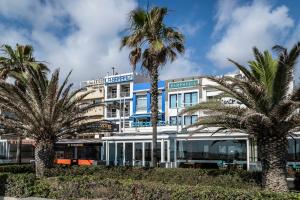 un bâtiment avec des palmiers en face de celui-ci dans l'établissement PAMPHYLIA HOTEL, à Valence