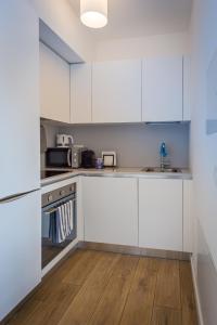 una cucina con armadietti bianchi e pavimenti in legno di Modern apartment in Lugano a Lugano