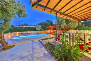 - une piscine dans un jardin avec une pergola en bois dans l'établissement Villa Candan Kaş, à Antalya