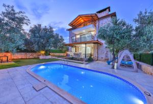 une maison avec une piscine en face d'une maison dans l'établissement Villa Candan Kaş, à Antalya