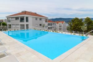 une grande piscine bleue en face d'un bâtiment dans l'établissement Malo More Resort, à Trogir