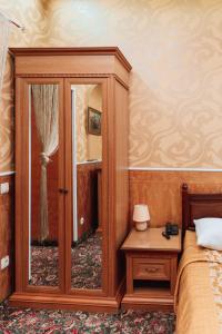 1 dormitorio con armario de madera y espejo en Viktoriya Family Hotel Restaurant complex, en Kiev