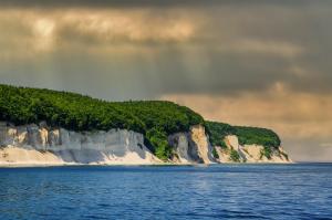 een eiland in de oceaan met een regenboog in de lucht bij Boddenhus auf Rügen - Ferienwohnungen und Pension in Rappin