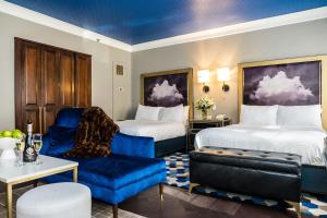 a hotel room with two beds and a blue chair at The Goodwin in Hartford