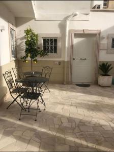 een patio met een tafel en stoelen op een stenen vloer bij Casa di Fló in Bari