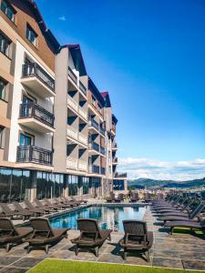 un hôtel avec une piscine et des chaises longues dans l'établissement Premium Club SPA, à Bukovel