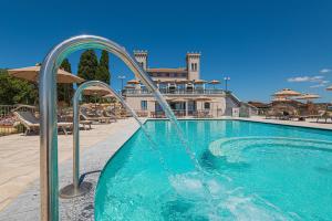 uma piscina com uma fonte de água em frente a um edifício em Castello Bonaria Wine & Spa Resort em Campiglia Marittima