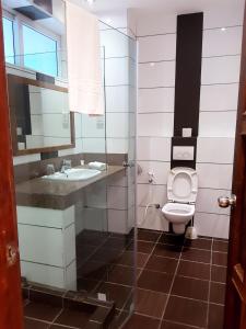 a bathroom with a toilet and a sink at Cowrie Shell Beach Apartments Official in Bamburi