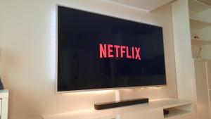 una televisione su un muro con il cartello netflix sopra di Luxury Studio In the EU Area a Bruxelles