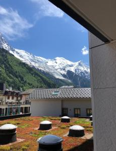 Blick auf ein Gebäude mit einem schneebedeckten Berg in der Unterkunft Ladybird Inn in Chamonix-Mont-Blanc