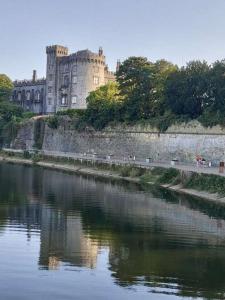 un castillo sentado al lado de un río en Castle Lodge Kilkenny, en Kilkenny