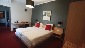 a hotel room with two beds with red pillows at La Chrysalide in Étalle