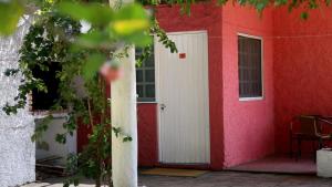 een rood-wit huis met een witte deur bij Complejo Turistico Chuy in Barra del Chuy