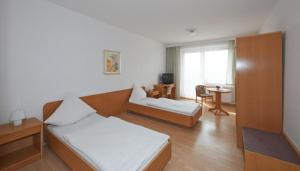 Giường trong phòng chung tại Alpha Apparthotel leipzig-Rötha