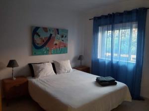 een slaapkamer met een groot wit bed en blauwe gordijnen bij Sunset Village Apartment - Brisa Da Ericeira in Ericeira